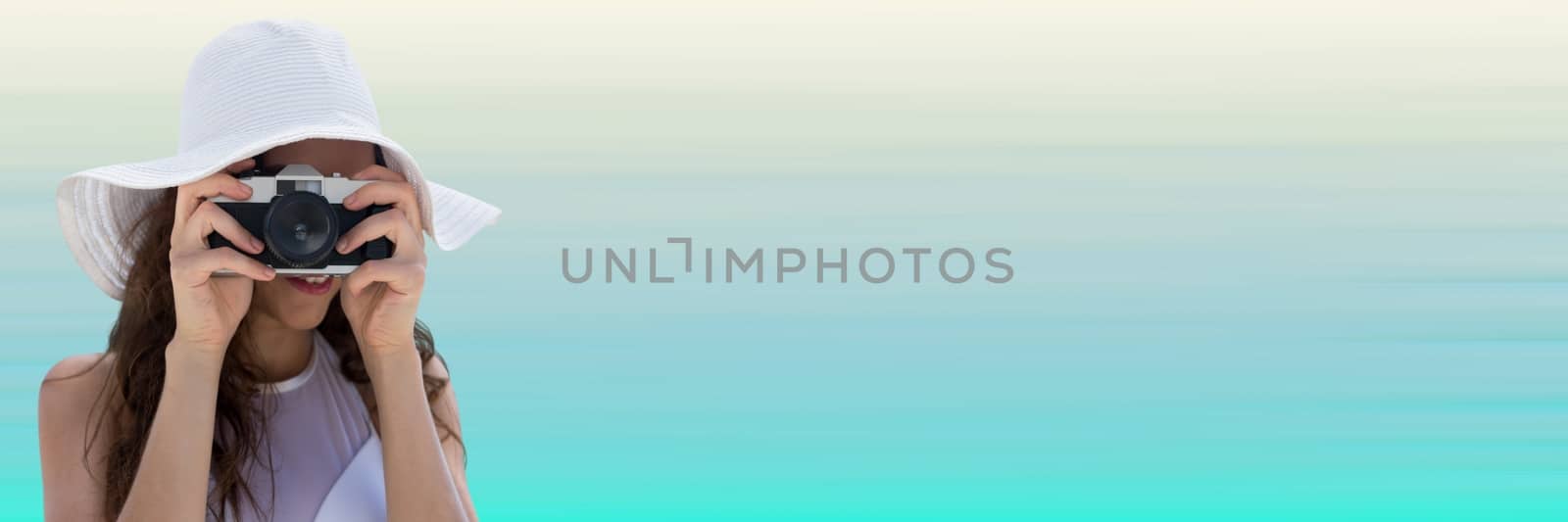 Digital composite of Millennial woman in summer hat with camera against light blue background