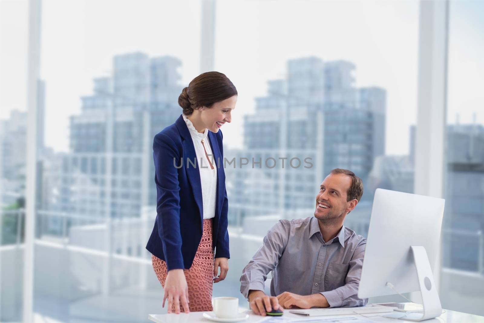 Business people at a desk smiling by Wavebreakmedia