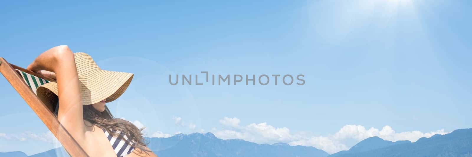 Digital composite of Woman sunbathing against mountain tops and Summer sky