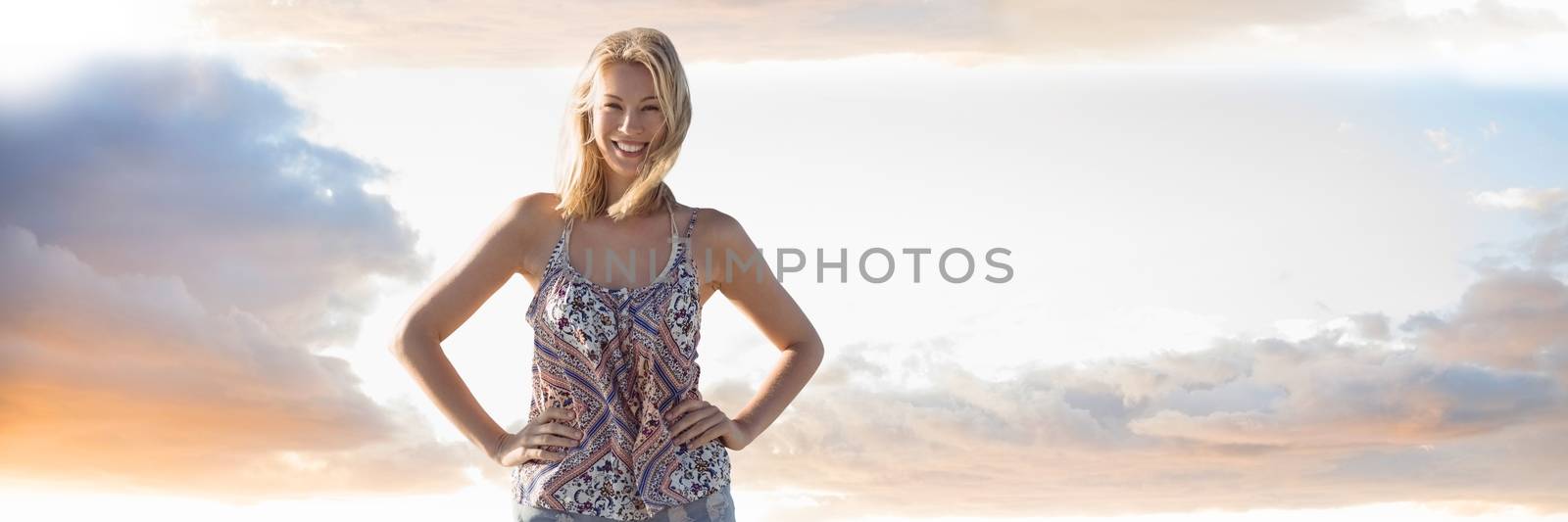 Woman in summer clothes with hands on hips against cloudy sky by Wavebreakmedia
