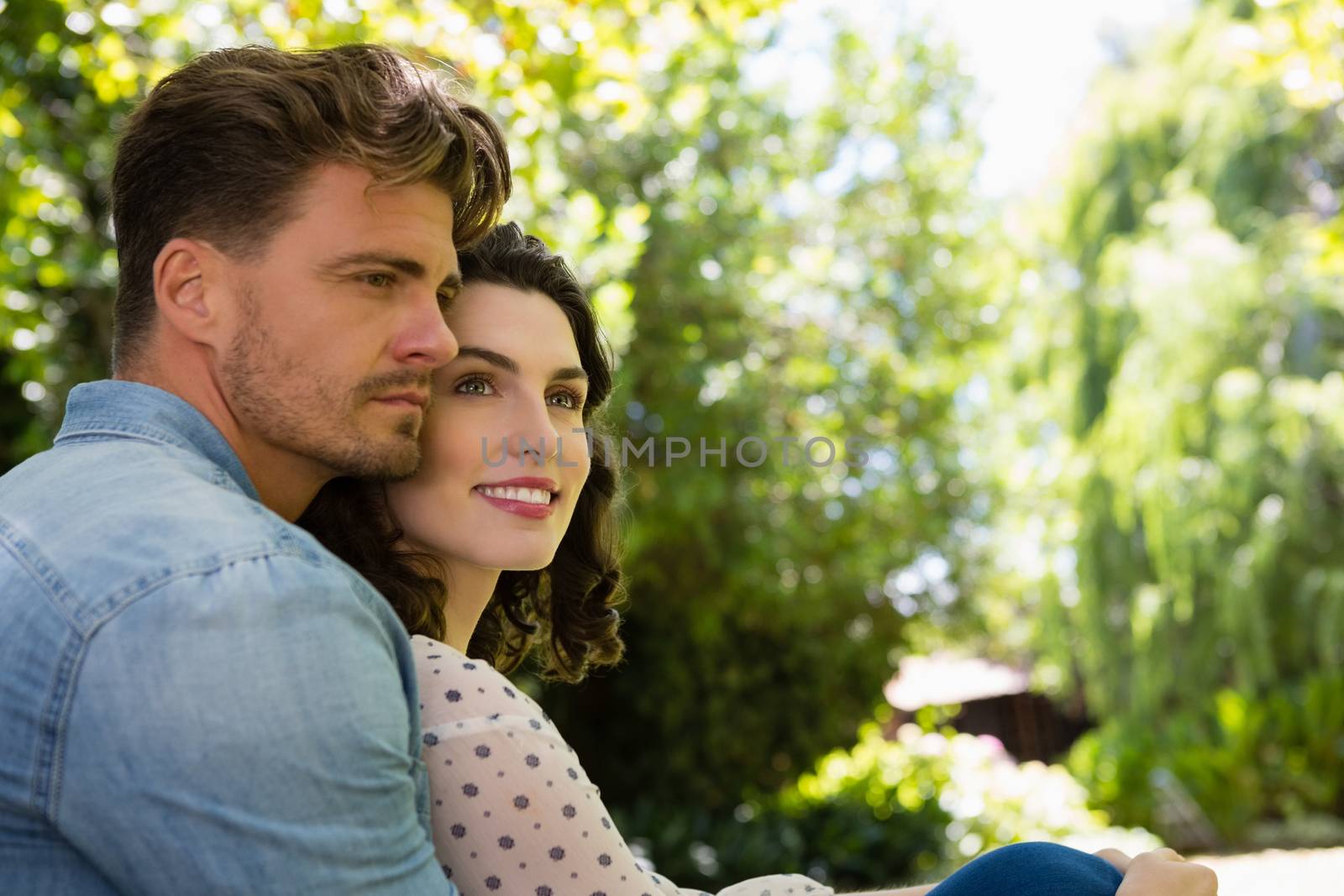Romantic couple embracing each other in garden on a sunny day