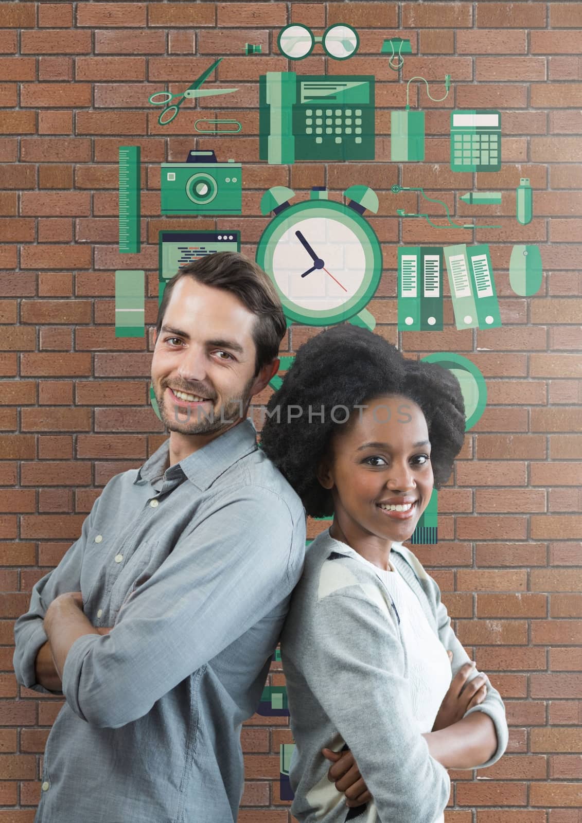 Happy business people standing against brick wall with graphics by Wavebreakmedia