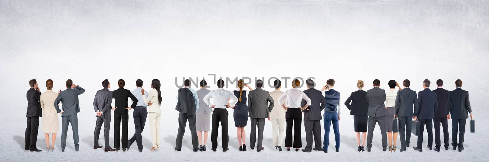Group of business people standing in front of blank grey background by Wavebreakmedia