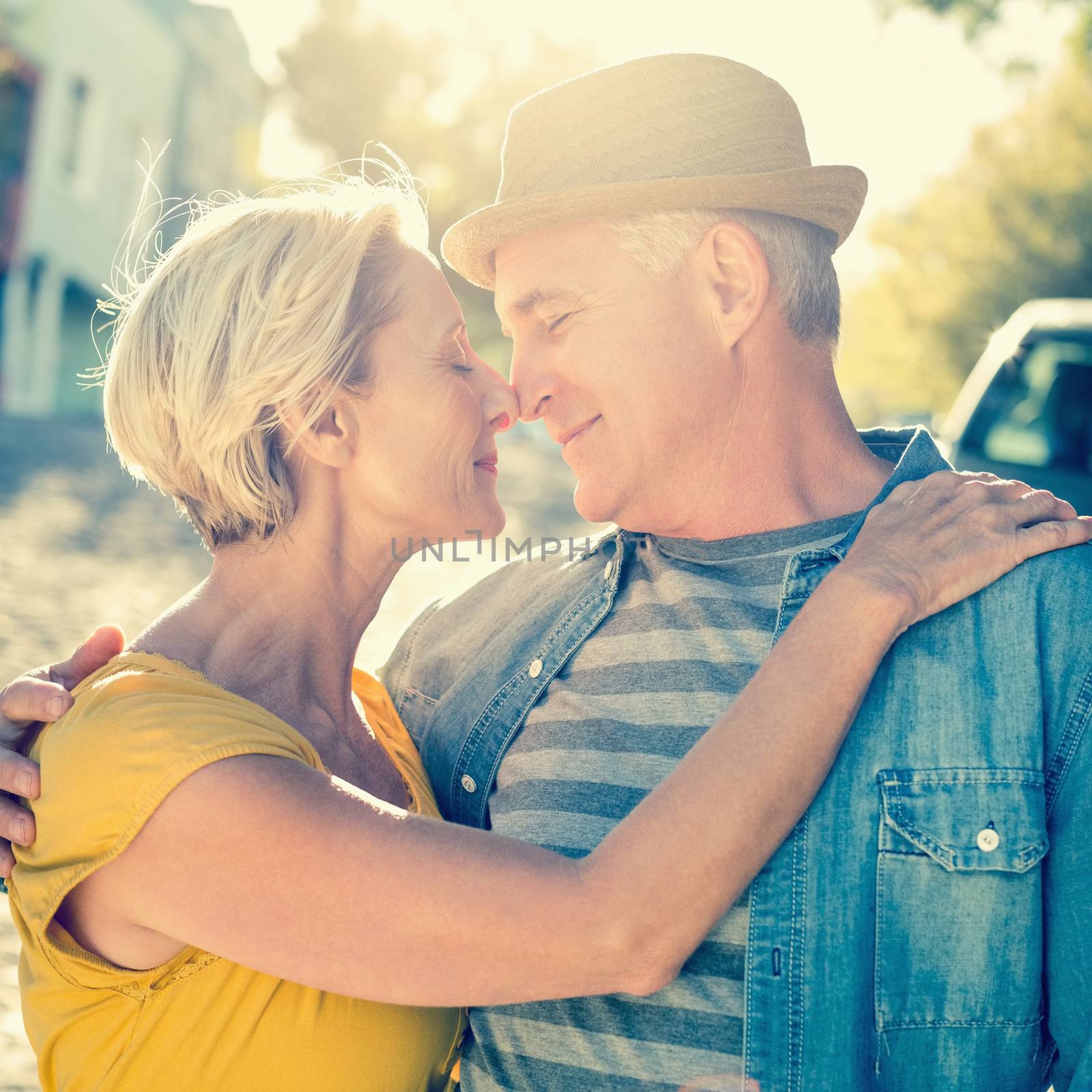 Happy mature couple smiling at each other in the city on a sunny day