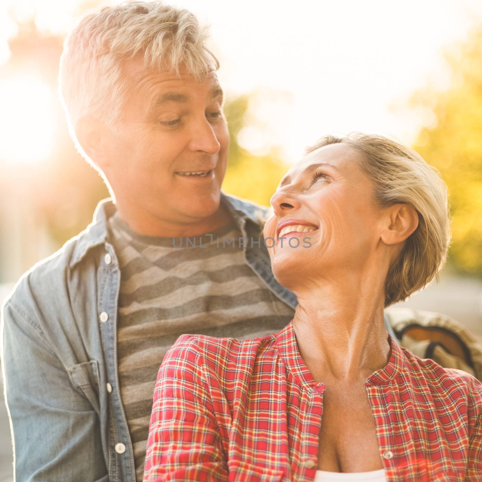 Happy mature couple hugging in the city on a sunny day