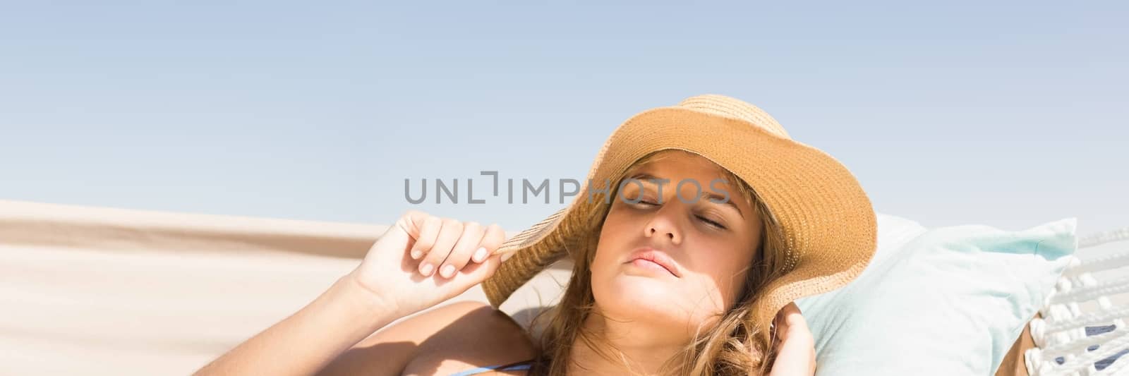 Digital composite of Millennial woman with sun hat asleep on hamoc against Summer sky