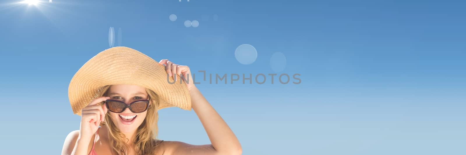 Digital composite of Millennial woman in sun hat and sunglasses against Summer sky with flare