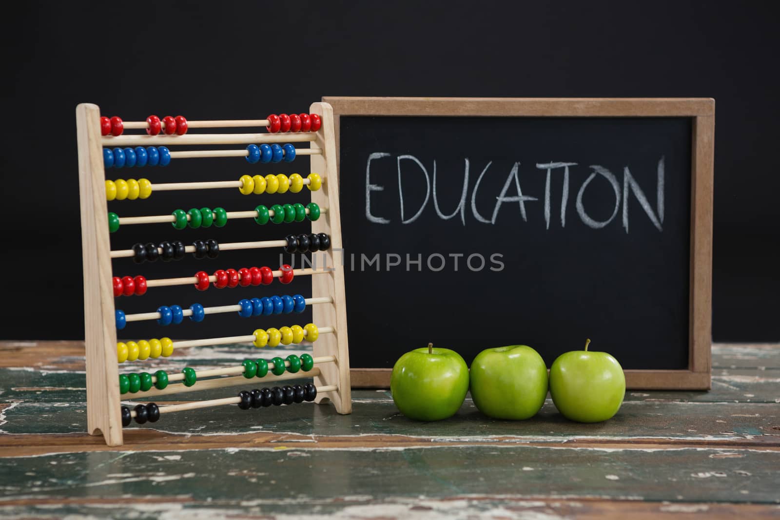 Education text on chalkboard with abacus and green apples by Wavebreakmedia