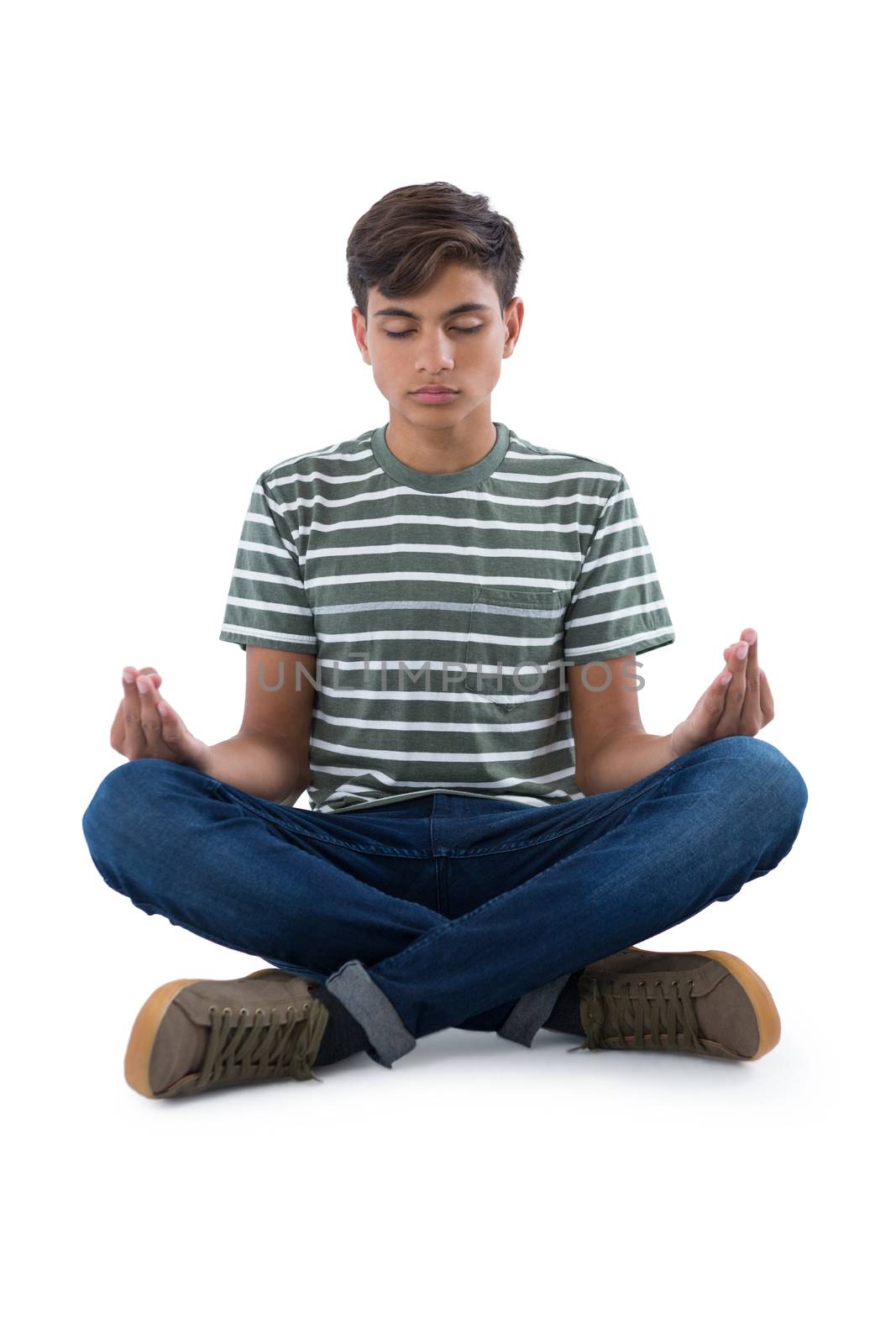 Teenage boy performing yoga against white background