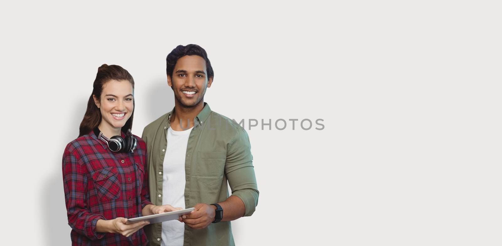 Portrait of people posing with digital tablet  against grey background