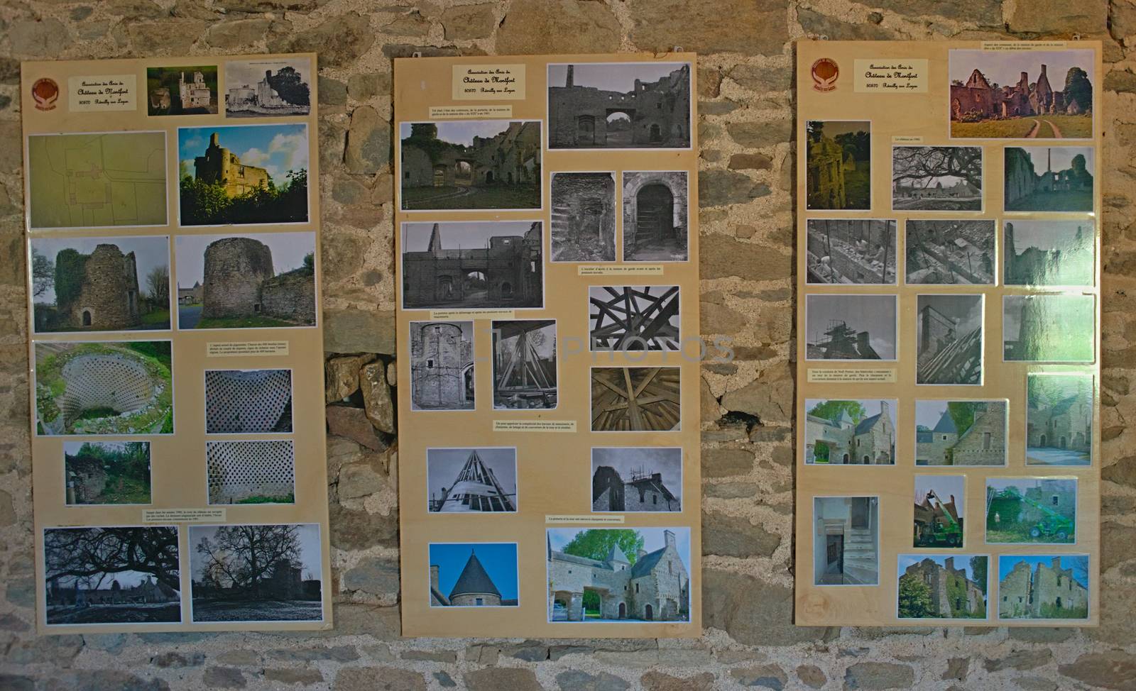 Montfort-sur-Risle, FRANCE - April 14th 2019 - Boards with old photograph of Monfort castle on stone wall by sheriffkule