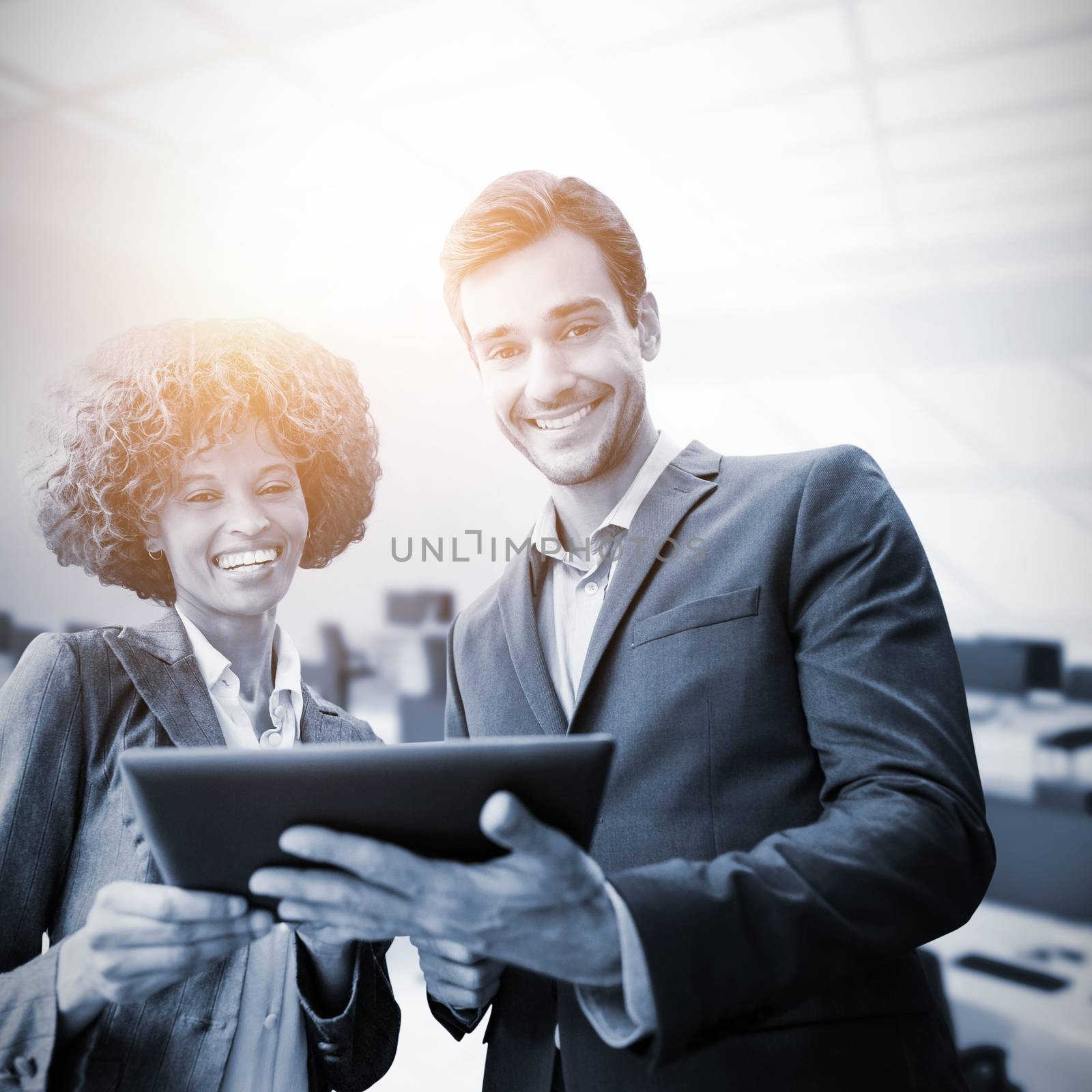 Business people standing with a tablet against computers in office