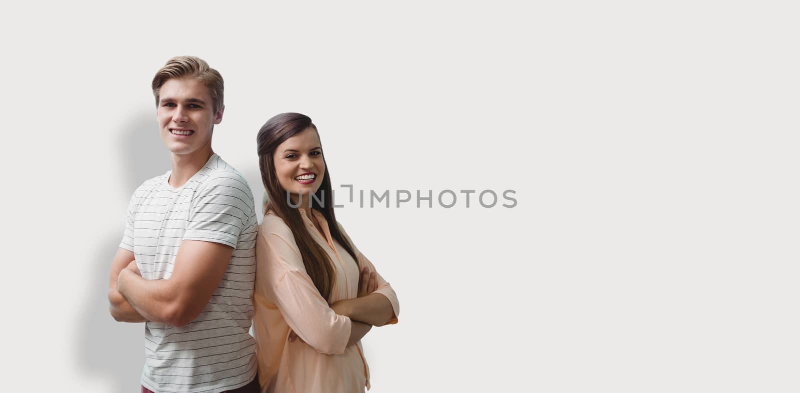 Young smiling people are posing with crossed arms  against grey background
