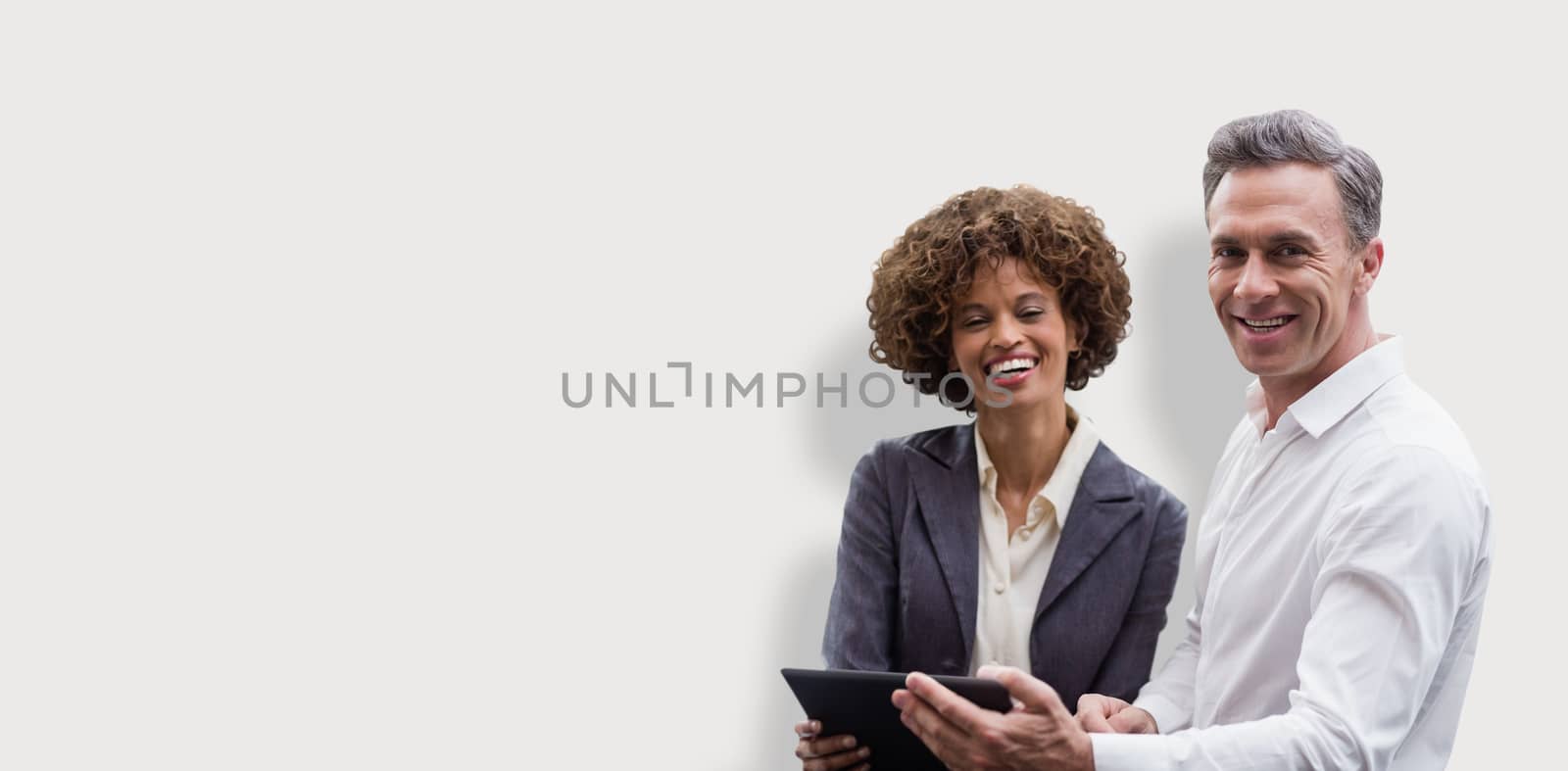 Portrait of business people posing with digital tablet  against grey background