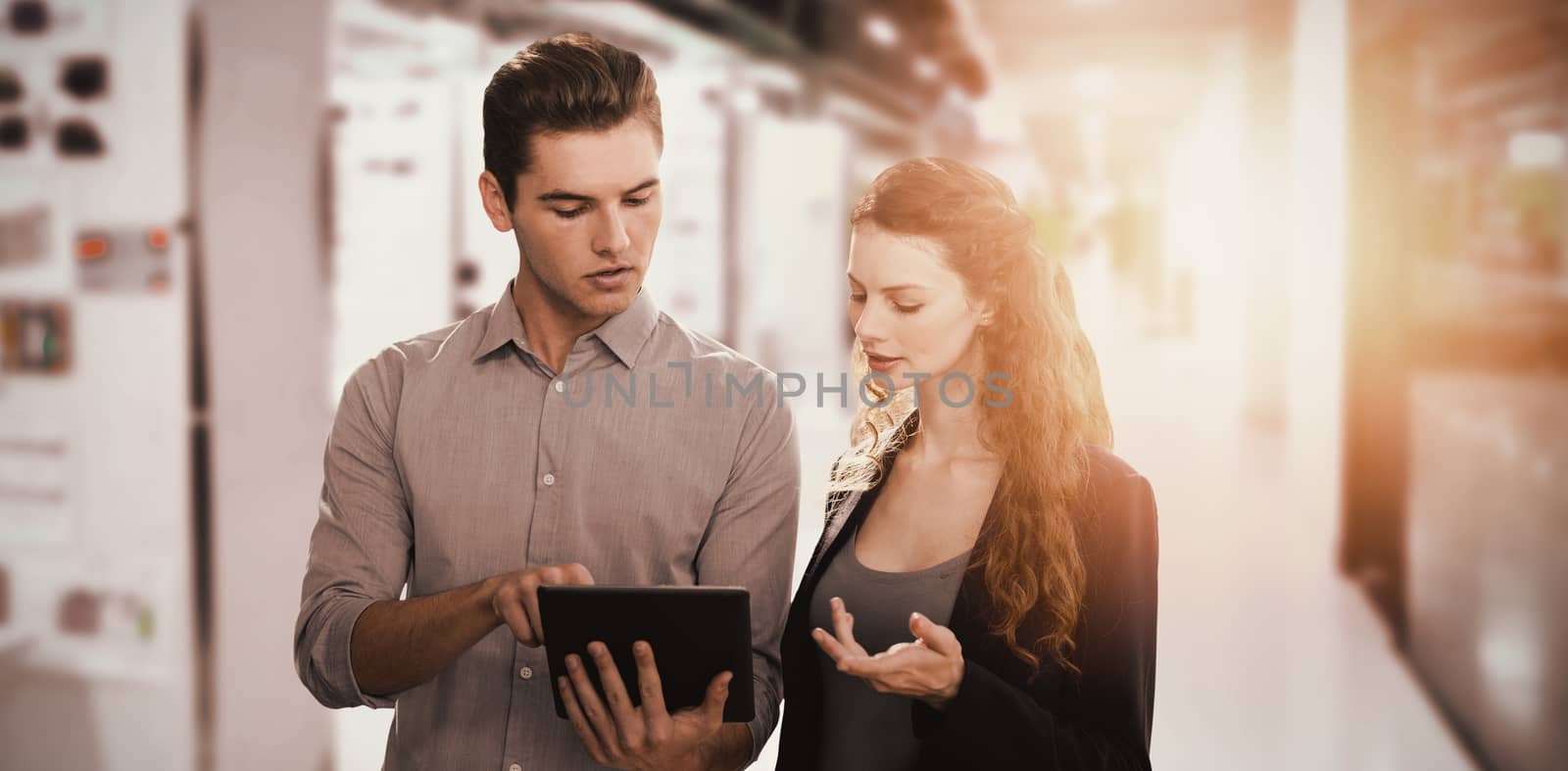 Concentrated business people using a digital tablet  against college hallway