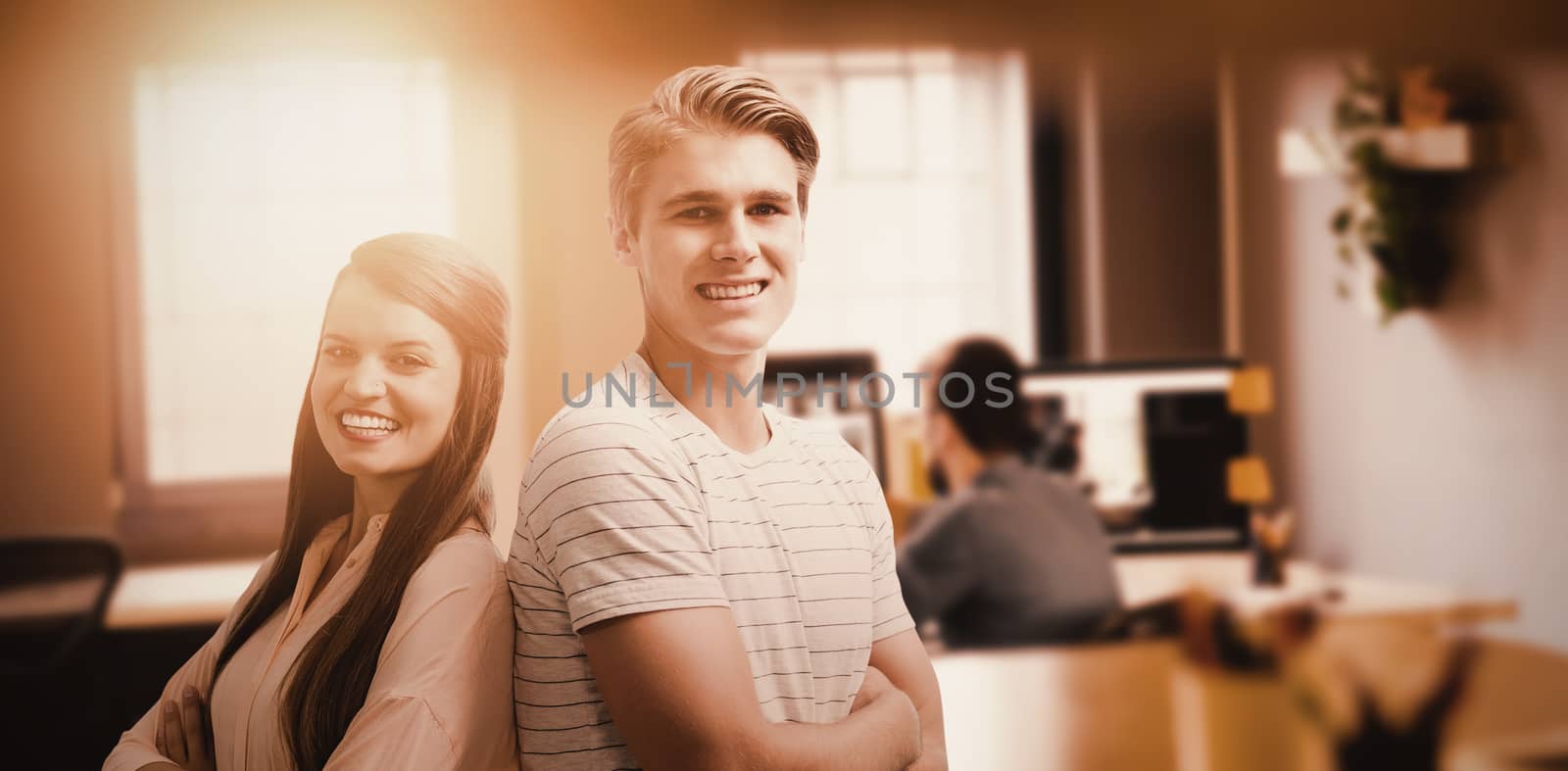 Young smiling people are posing with crossed arms  against graphic designer working at his desk
