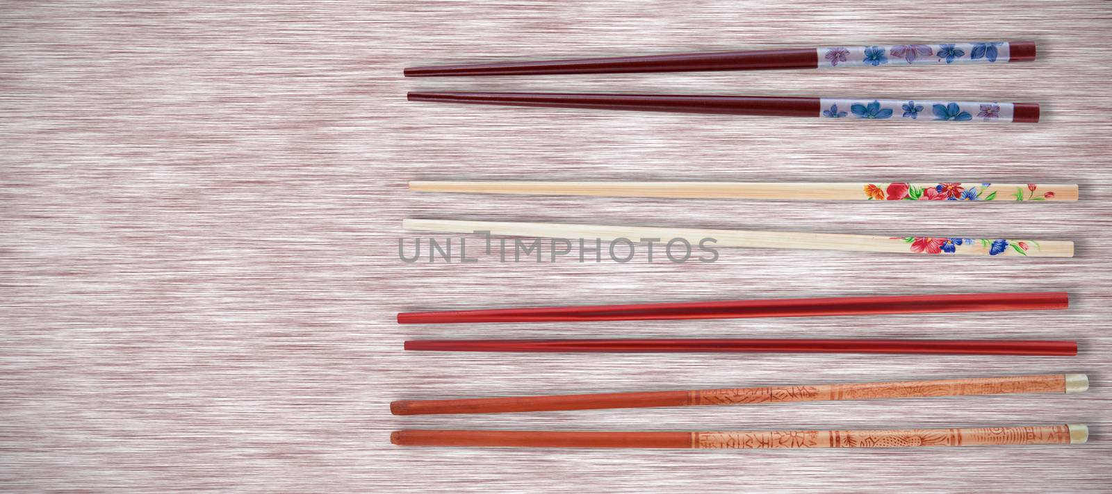 Chopsticks on white background against grey texture background