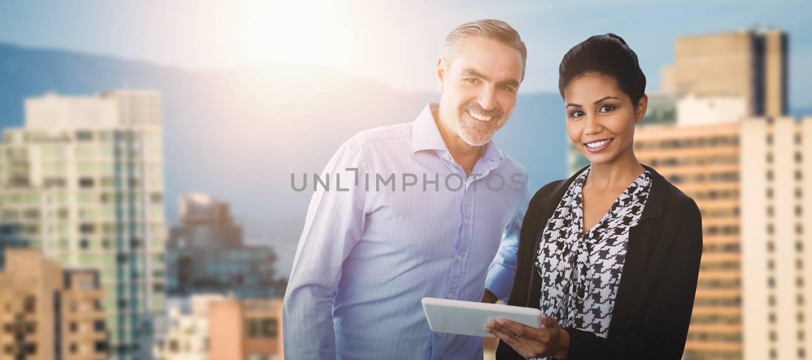 Business people looking at camera  against buildings against mountain