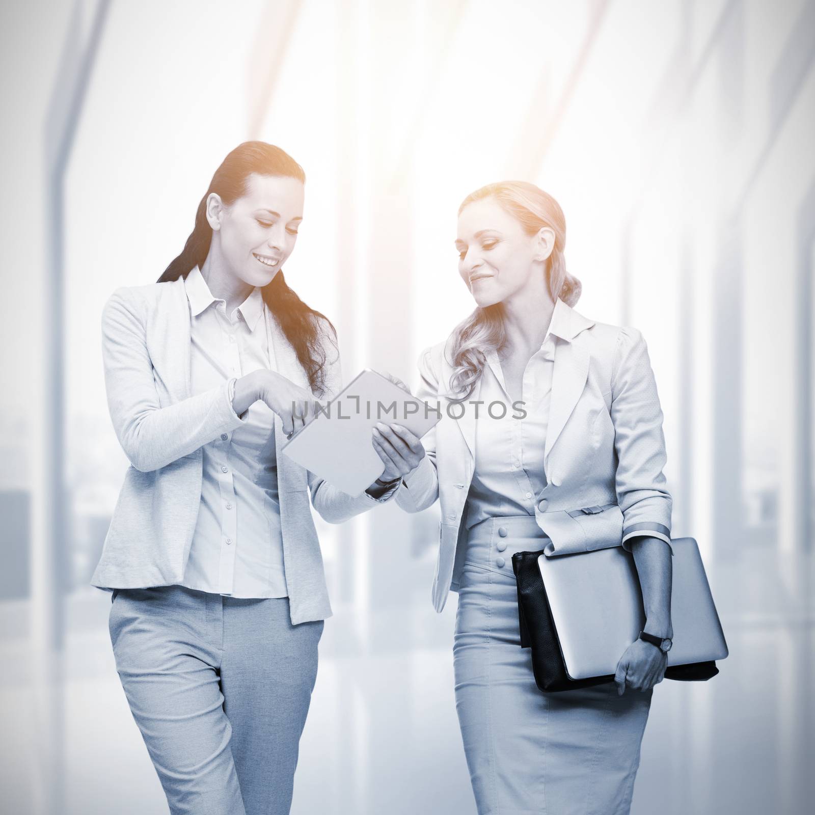 Composite image of businesswomen using digital tablet  by Wavebreakmedia