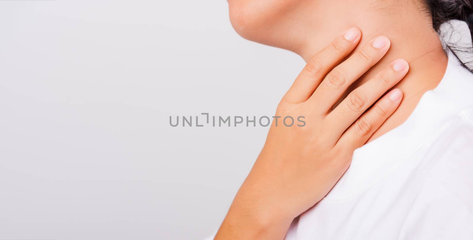 Asian beautiful woman Sore Throat or thyroid gland problem her useing Hand Touching Ill Neck on white background with copy space, Medical and Healthcare concept