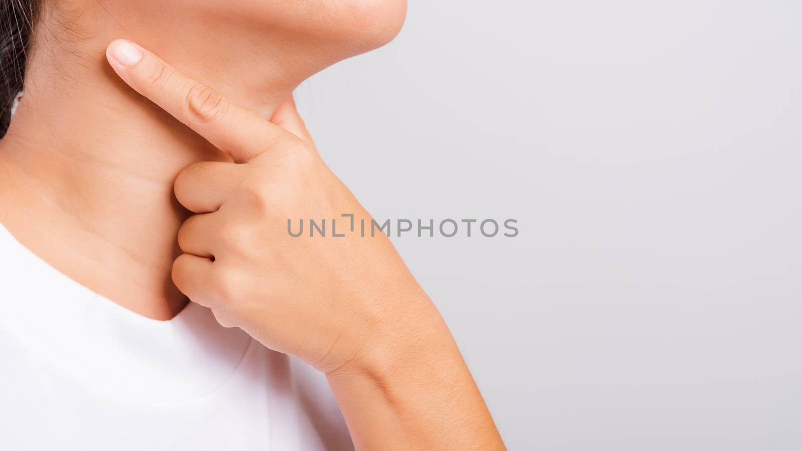 Asian beautiful woman Sore Throat or thyroid gland problem her useing Hand Touching Ill Neck on white background with copy space, Medical and Healthcare concept