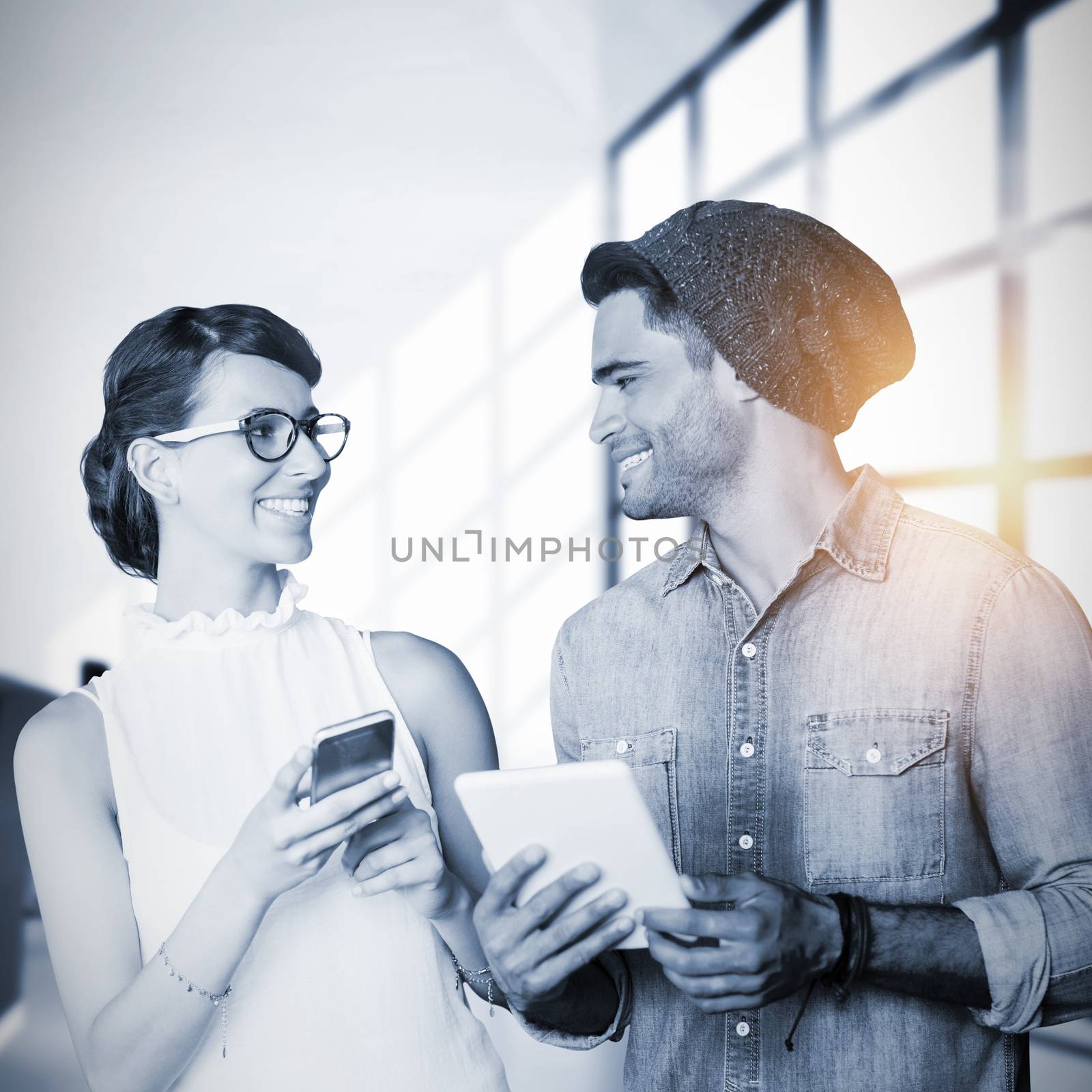 Composite image of smiling woman and man holding a phone and tablet by Wavebreakmedia
