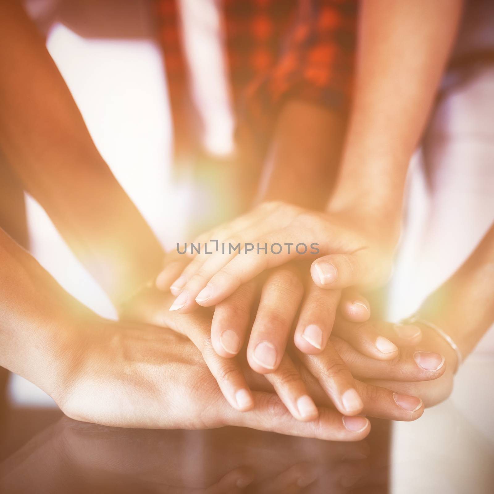 Business people stacking hands on table in office by Wavebreakmedia