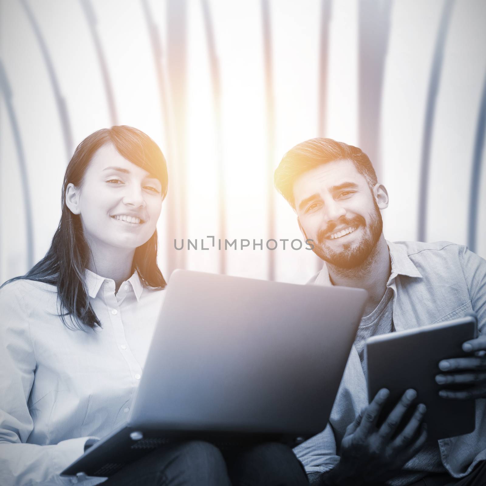 Composite image of business people sitting with laptop and tablet by Wavebreakmedia