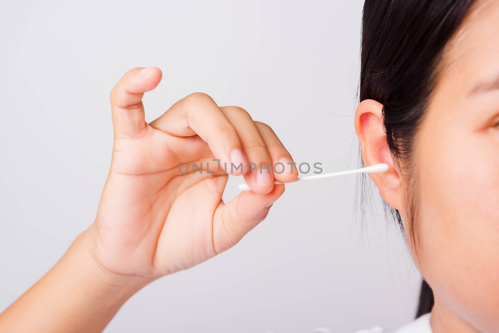 Asian beautiful woman cleaning ear hrt using cotton swab by Sorapop