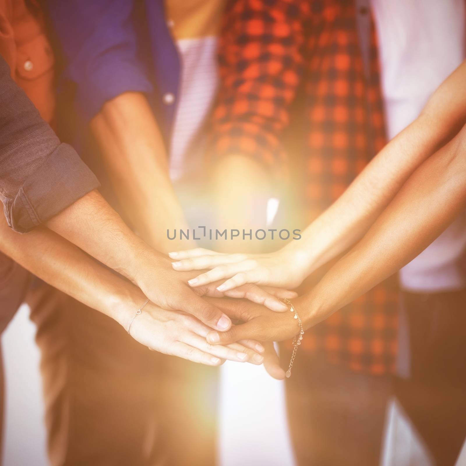 Mid section of business people stacking hands in office