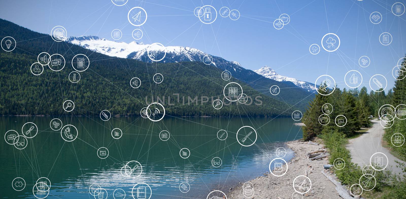 Technology icons against snowcapped mountain range by river with reflection against sky