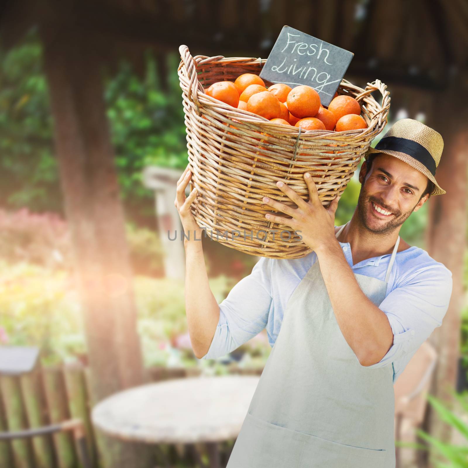 Composite image of smiling man carrying orange fruits in wicker basket by Wavebreakmedia