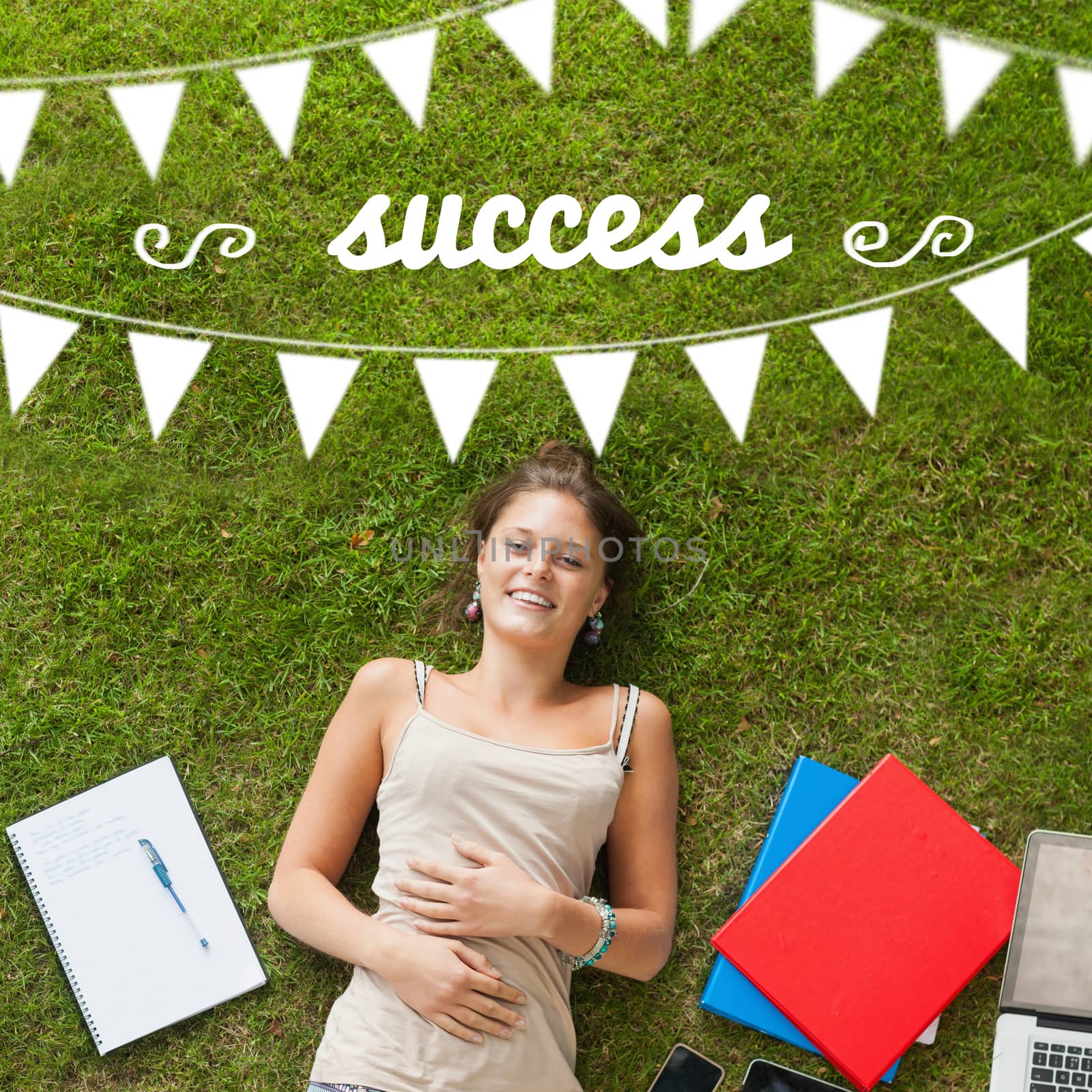 The word success and bunting against pretty student lying on grass