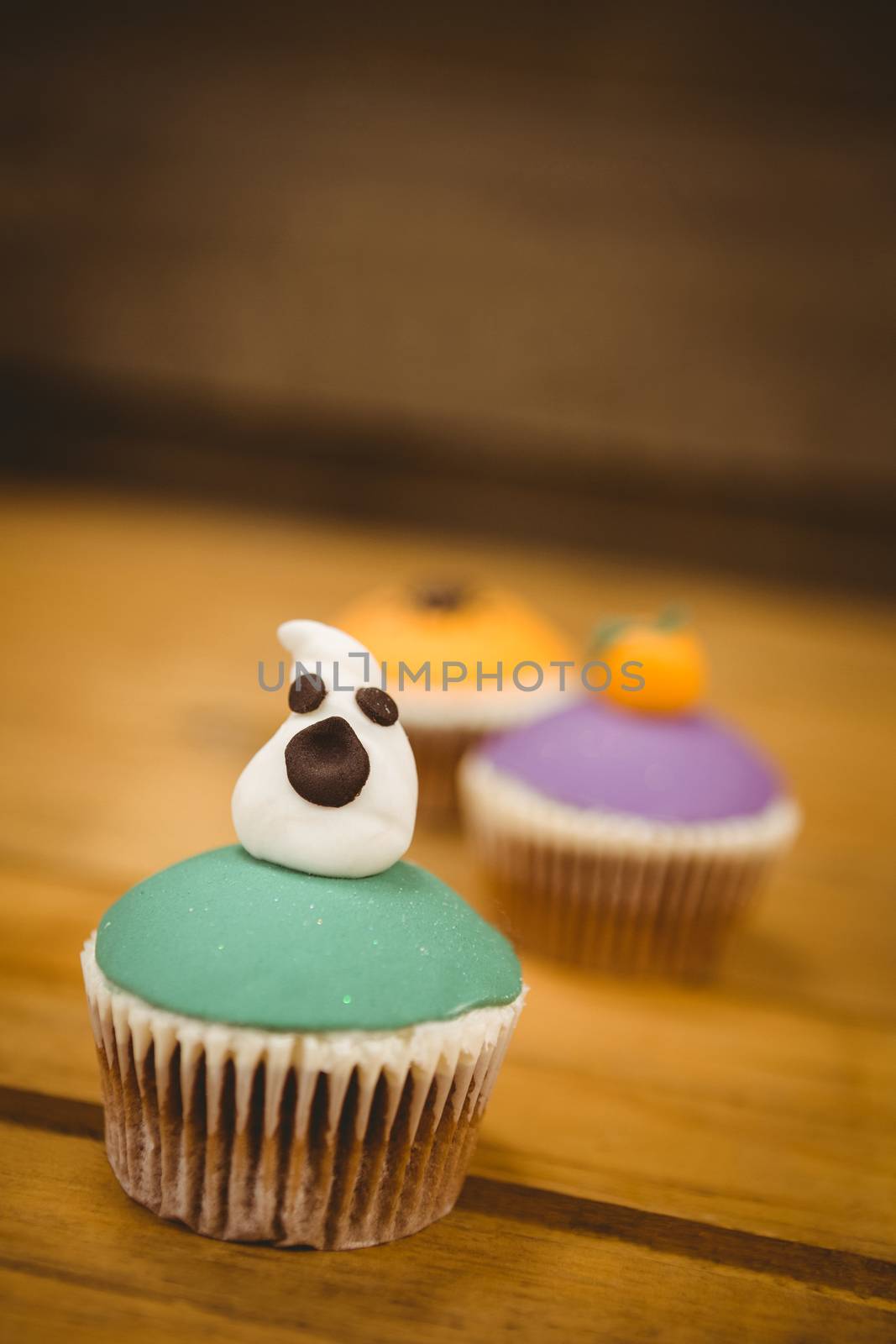 Cup cake with ghost on wooden table during Halloween by Wavebreakmedia