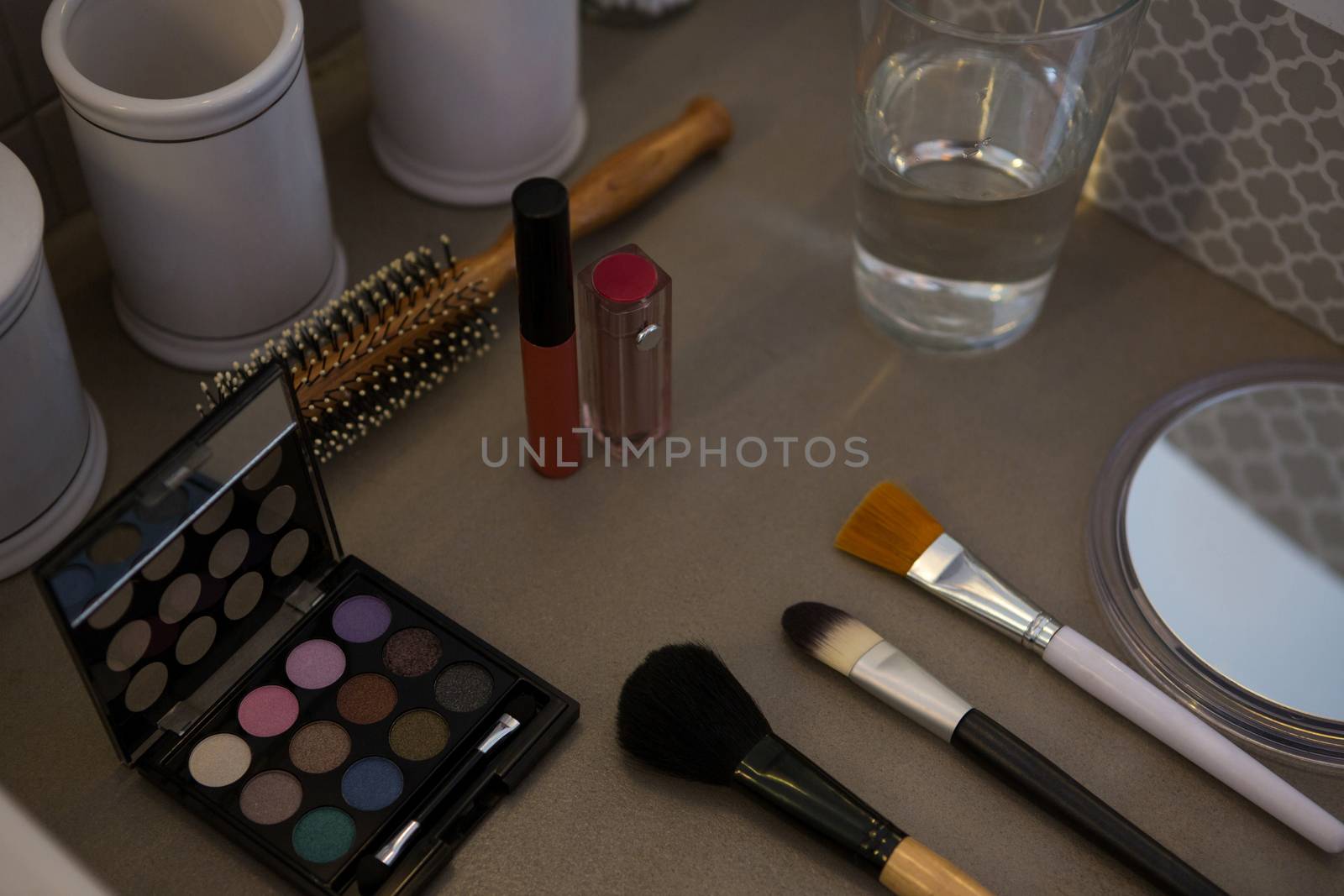 Beauty products with drinking glass on table by Wavebreakmedia