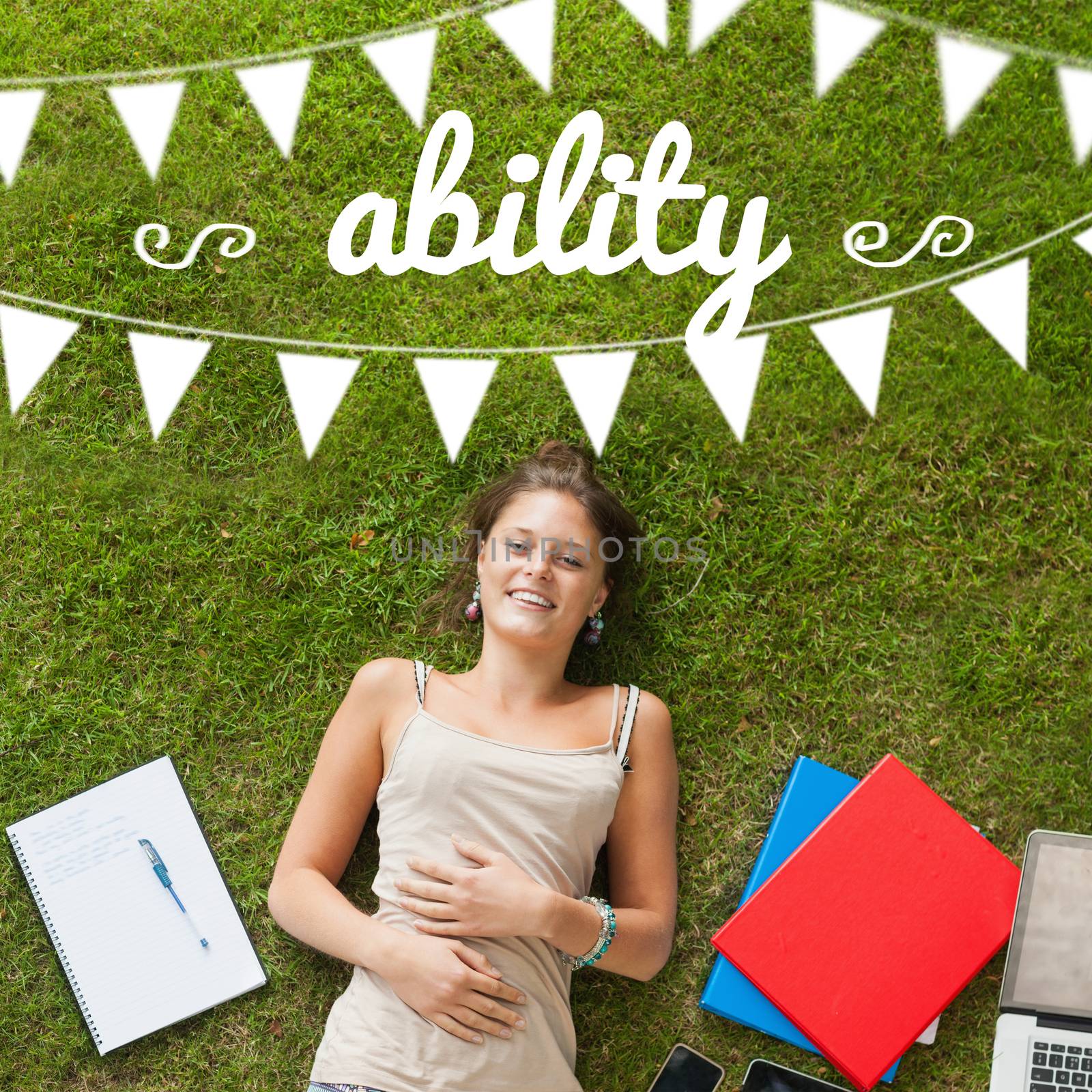 The word ability and bunting against pretty student lying on grass