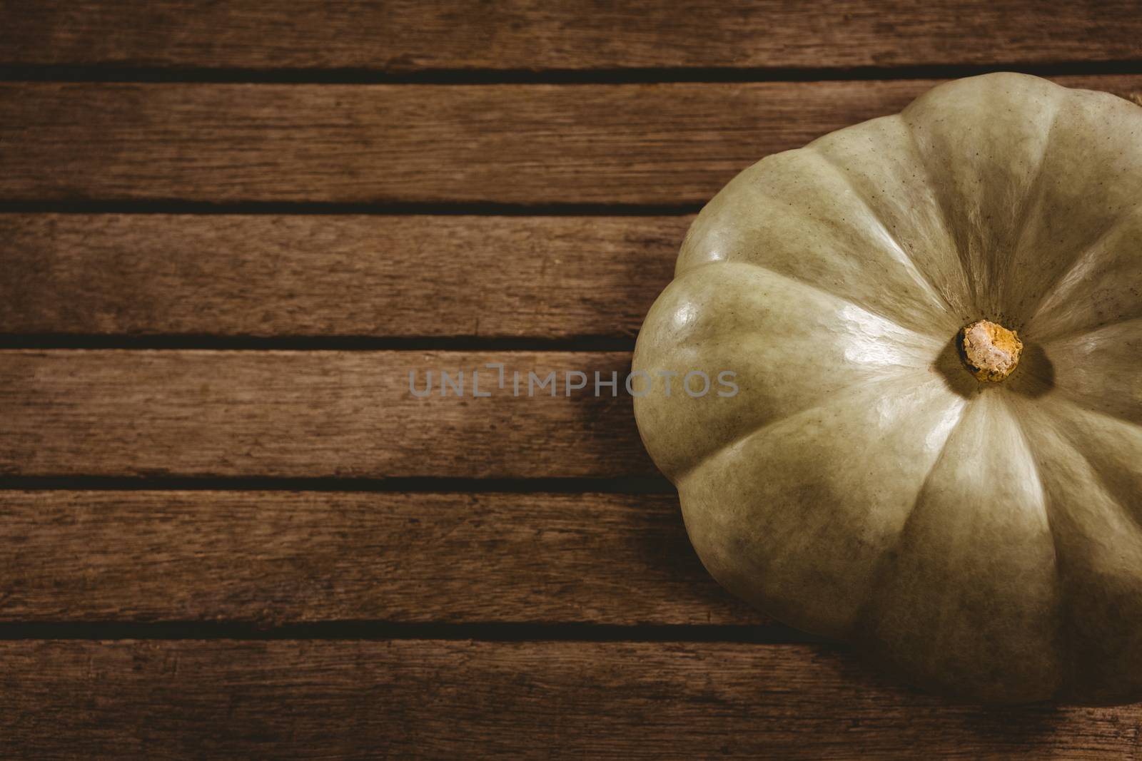 White pumpkin on wooden table during Halloween by Wavebreakmedia