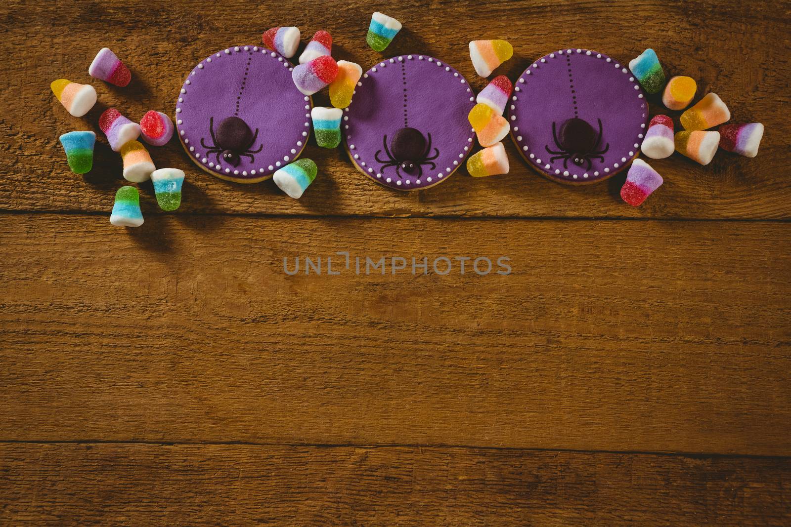 High angle view of Halloween cookies with candies on wooden table