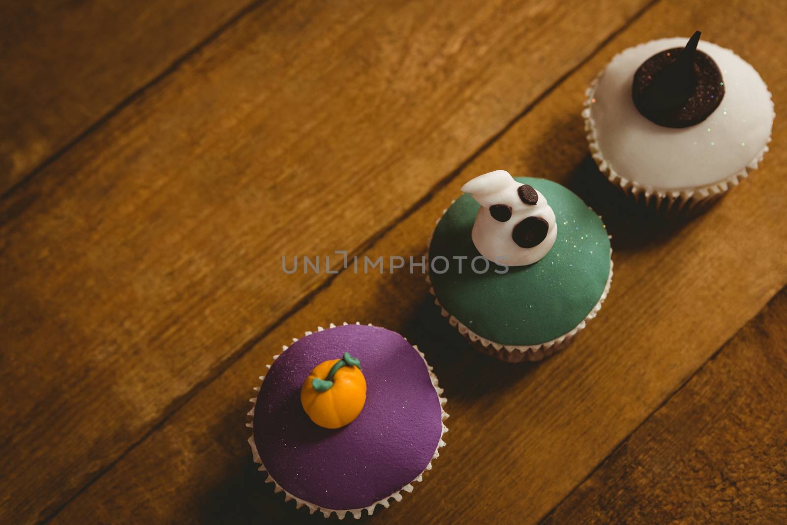 High angle view of Halloween cup cakes arranged on table by Wavebreakmedia