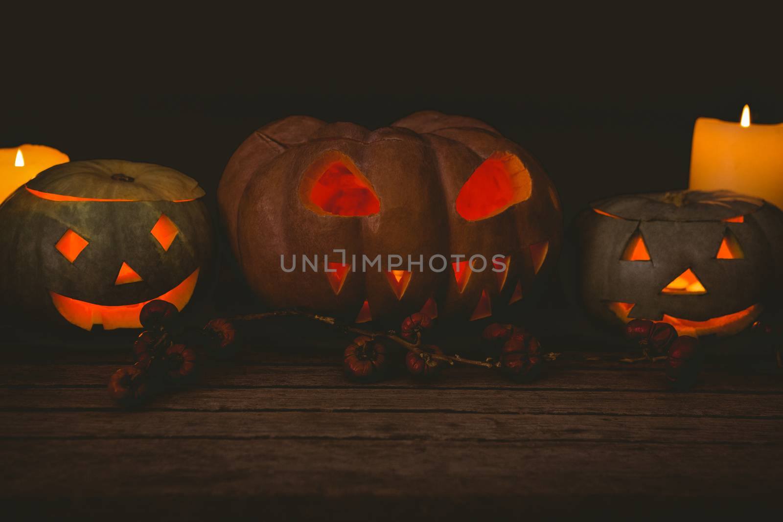 Illuminated jack o lantern with candles on table during Halloween by Wavebreakmedia