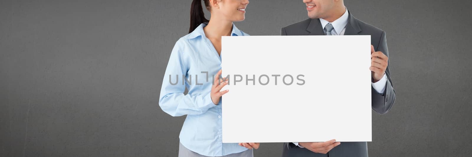 Digital composite of Business people holding a blank card against grey background