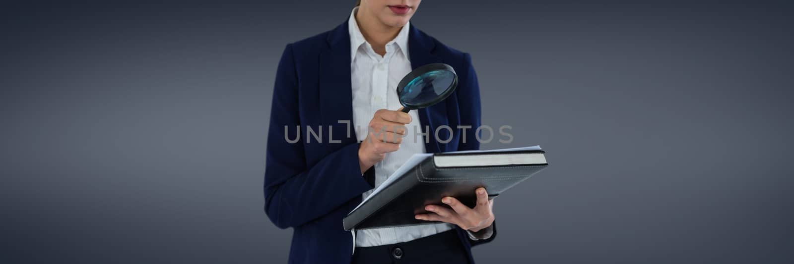 Woman with a magnifying glass against grey background as looking for an insurance concept by Wavebreakmedia