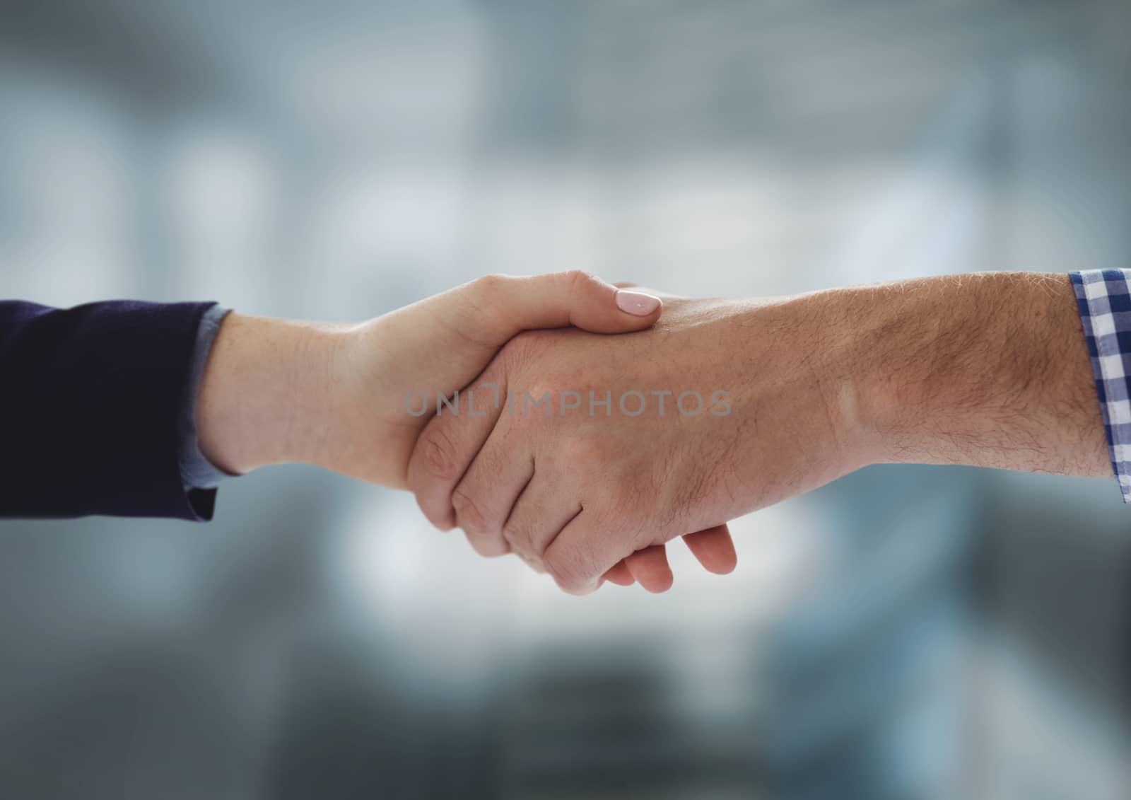 Digital composite of Business people shaking hands against blurred background