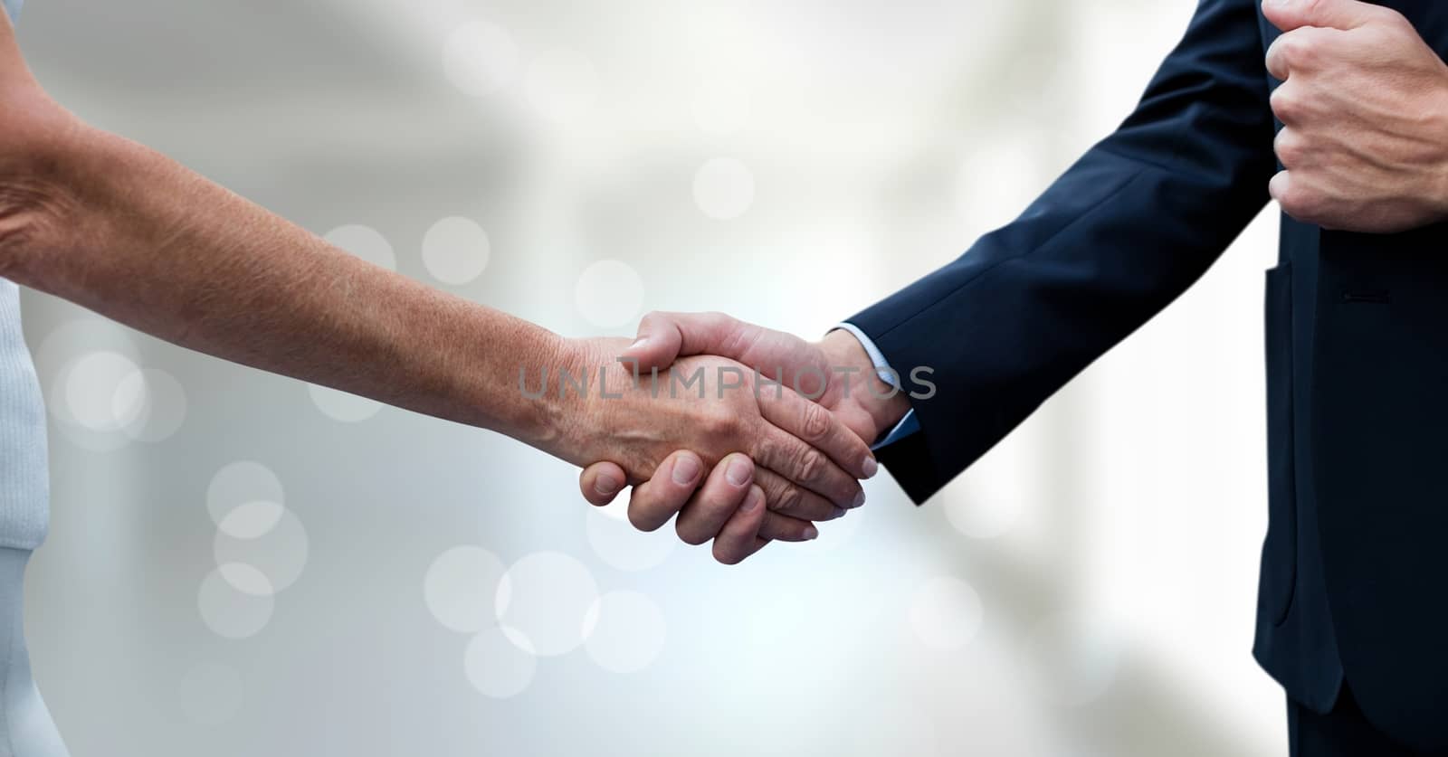 Digital composite of Business people shaking hands against blurred background