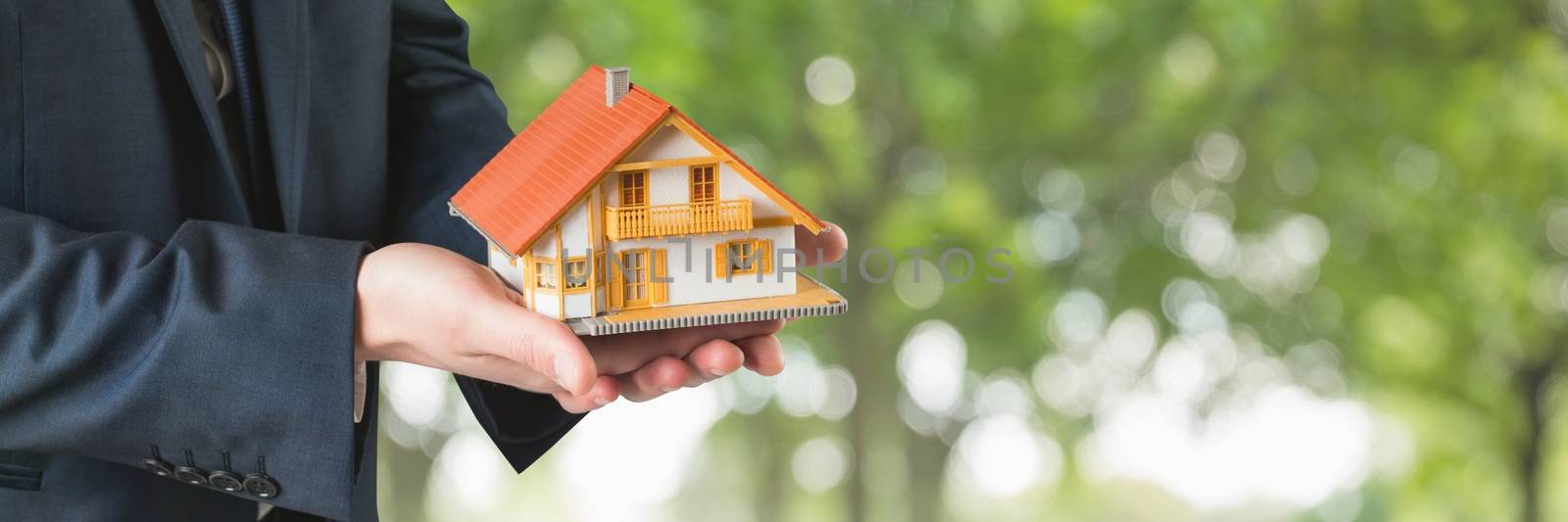 Digital composite of Man holding a house as house insurance concept