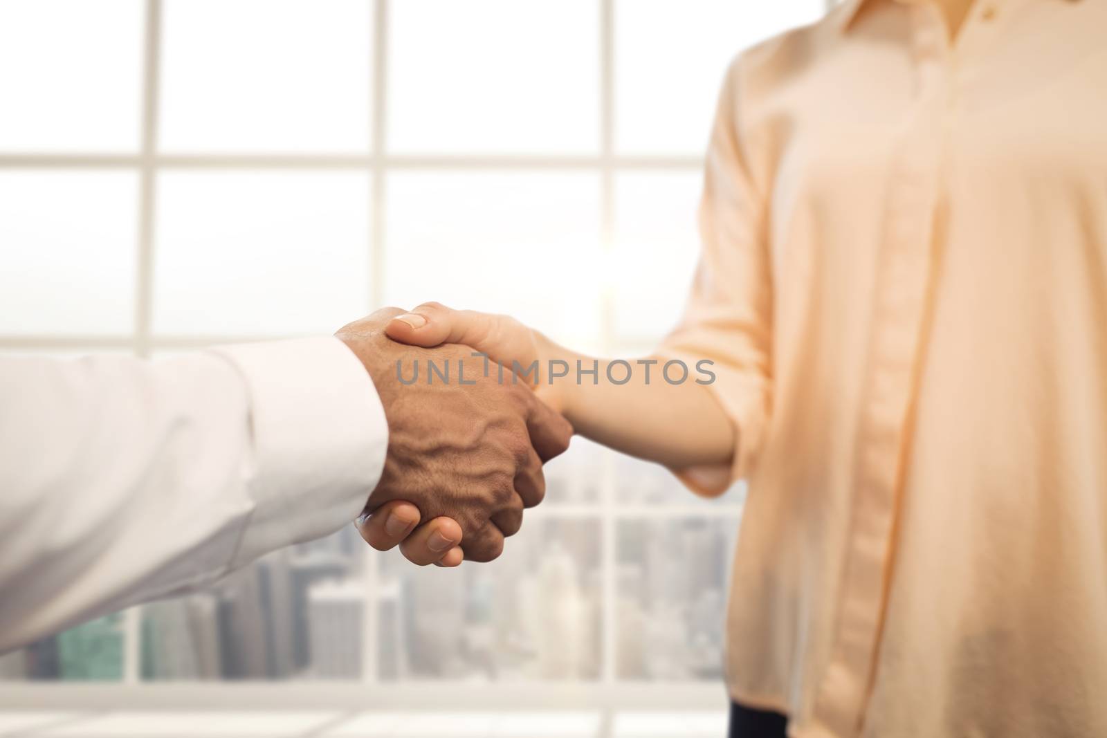 Digital composite of Business people shaking hands against city background