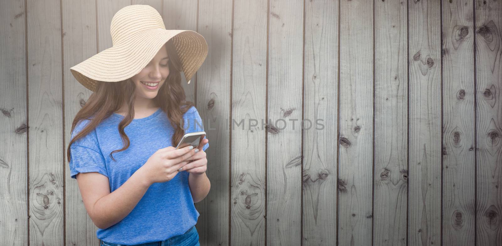 Brunette women wearing summer hat  against close-up of wooden fence