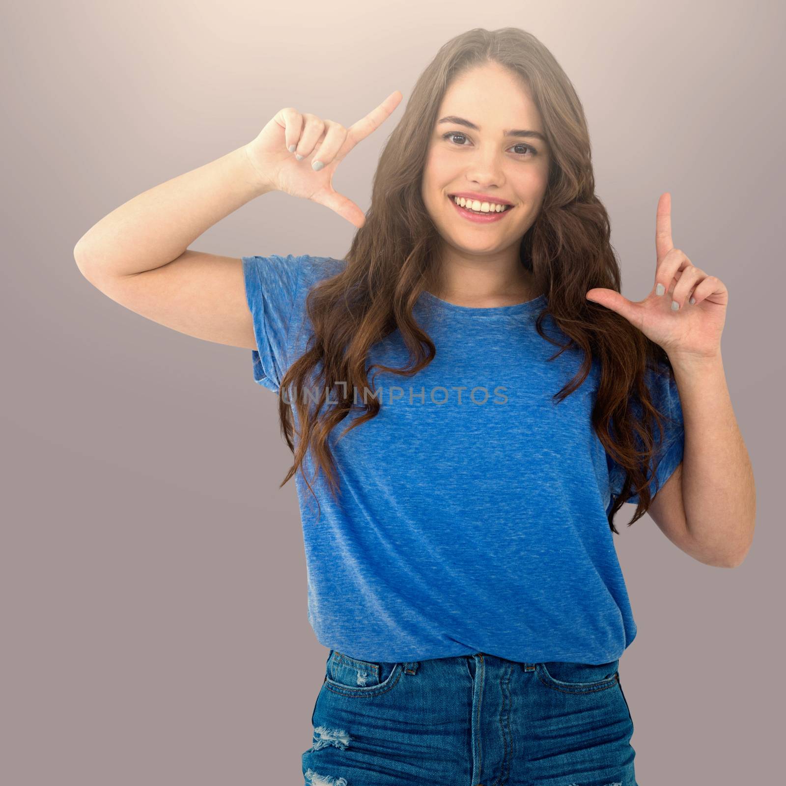 Portrait of female fashion model making frame with hands against grey background