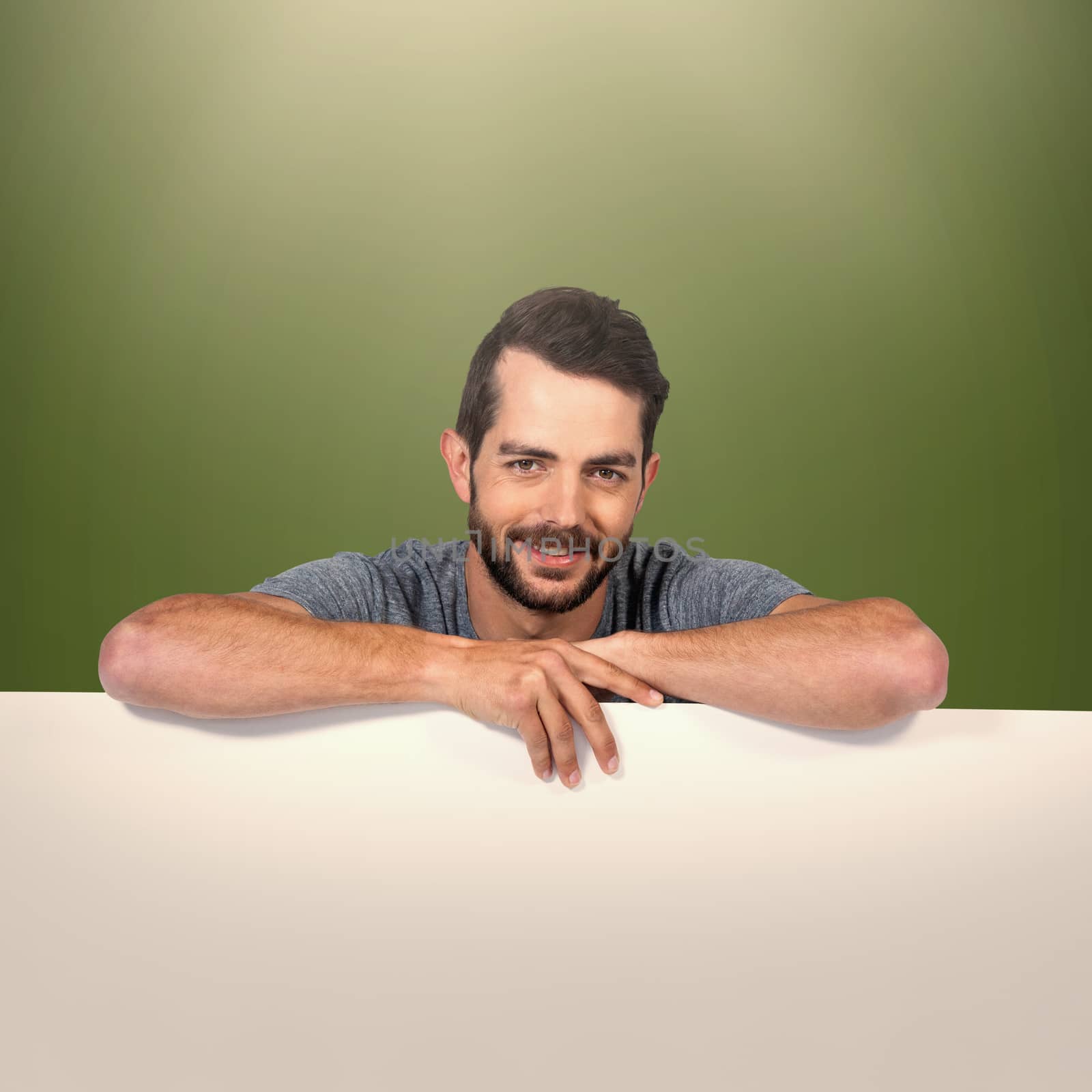 Portrait of smiling young man with cardboard against white background against green background