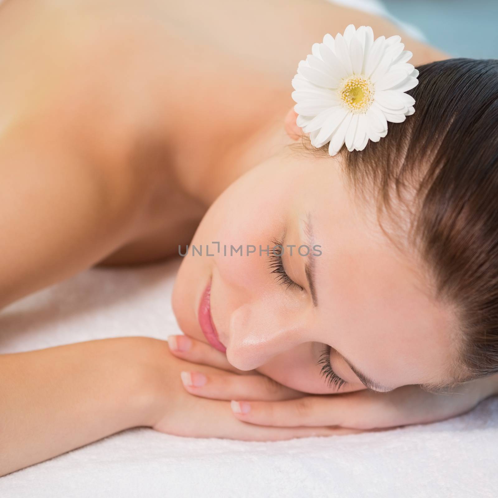Close up of a beautiful young woman lying on massage table at spa center